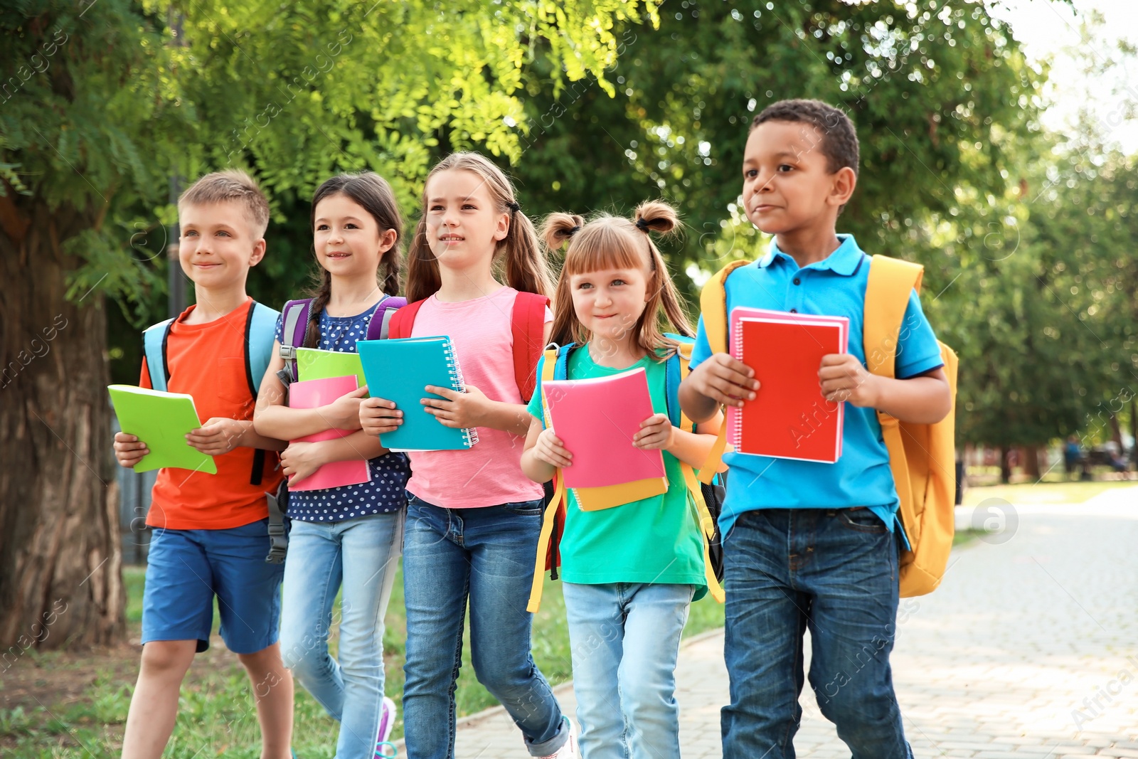 Photo of Cute little children with backpacks going to school