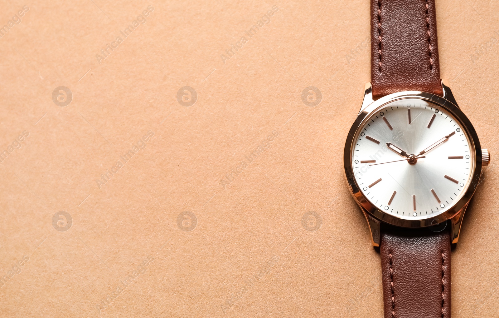 Photo of Luxury wrist watch on beige background, top view. Space for text