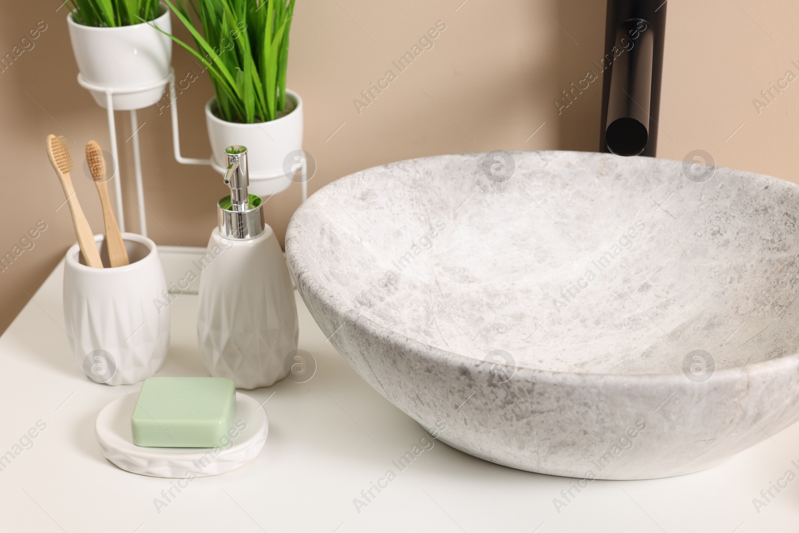 Photo of Different bath accessories and personal care products near sink on bathroom vanity