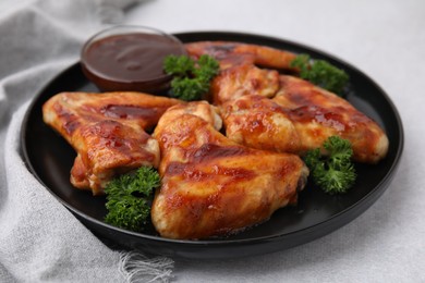 Photo of Fresh marinade and chicken wings on light table, closeup