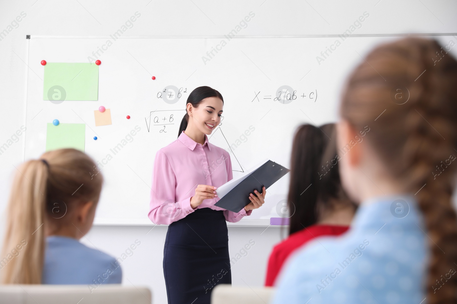 Photo of Young teacher and students in modern classroom