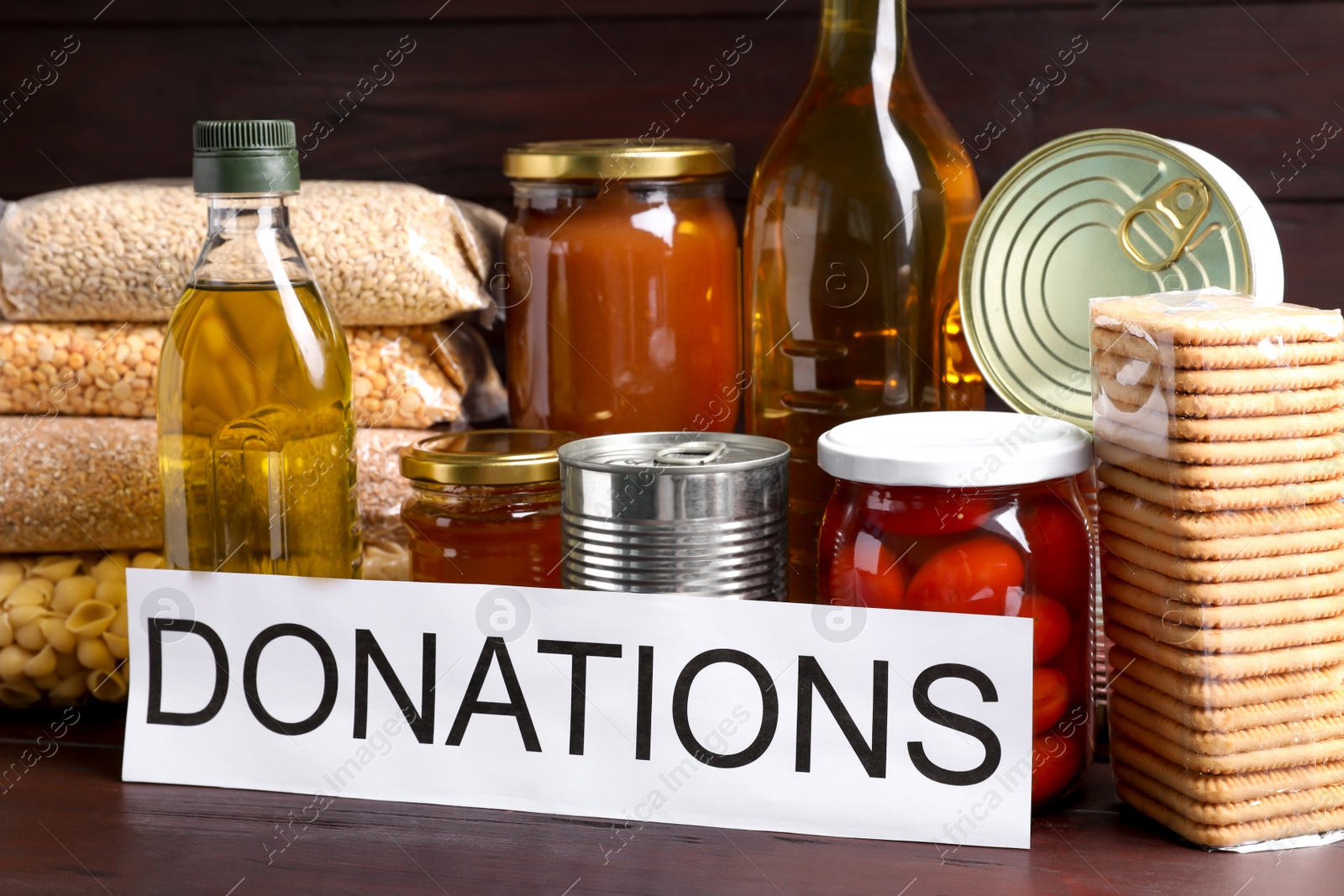 Photo of Card with word Donations and different products on wooden table