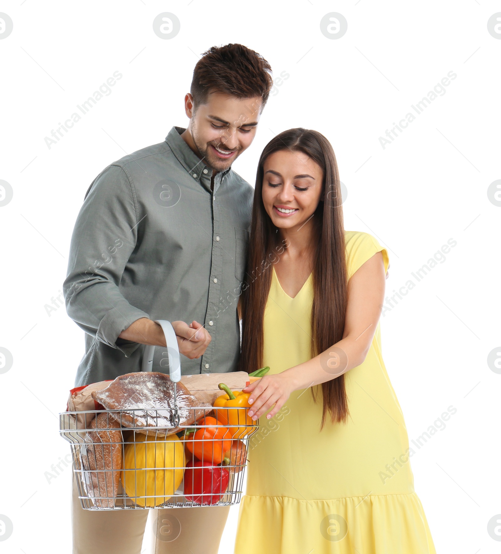 Photo of Young couple with shopping basket full of products isolated on white