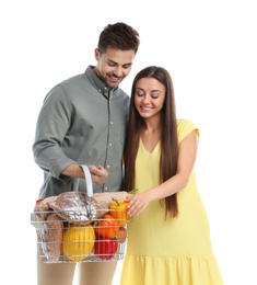 Young couple with shopping basket full of products isolated on white