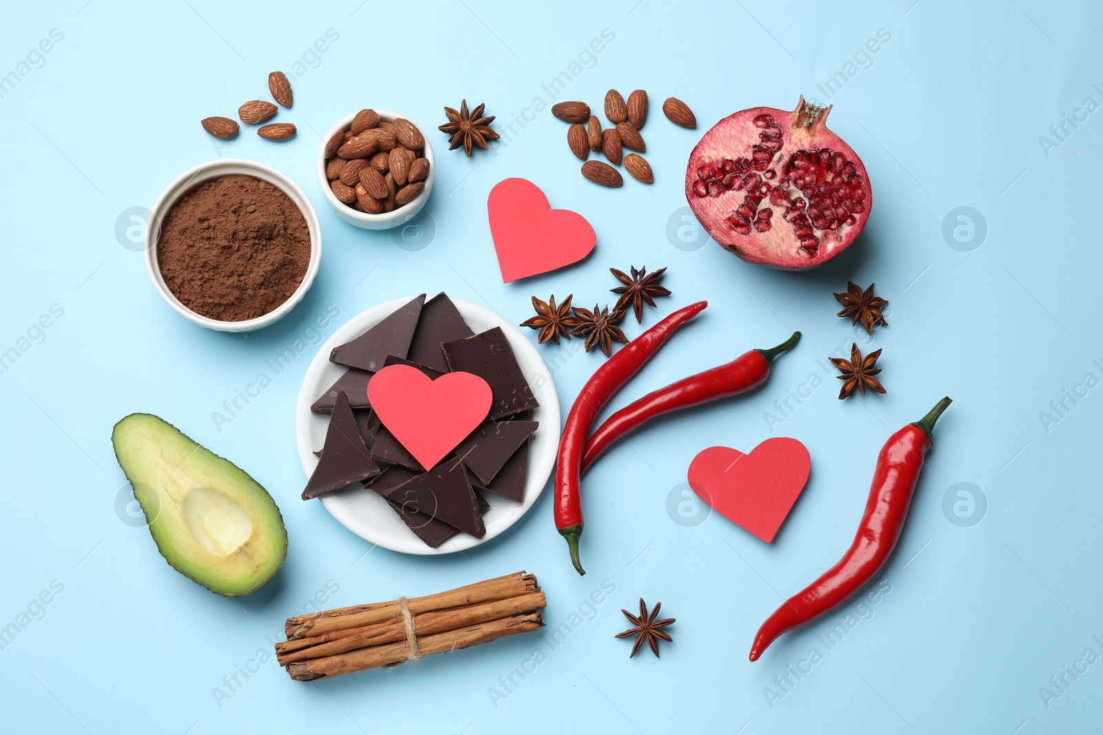 Photo of Natural aphrodisiac. Different products and paper hearts on light blue background, flat lay