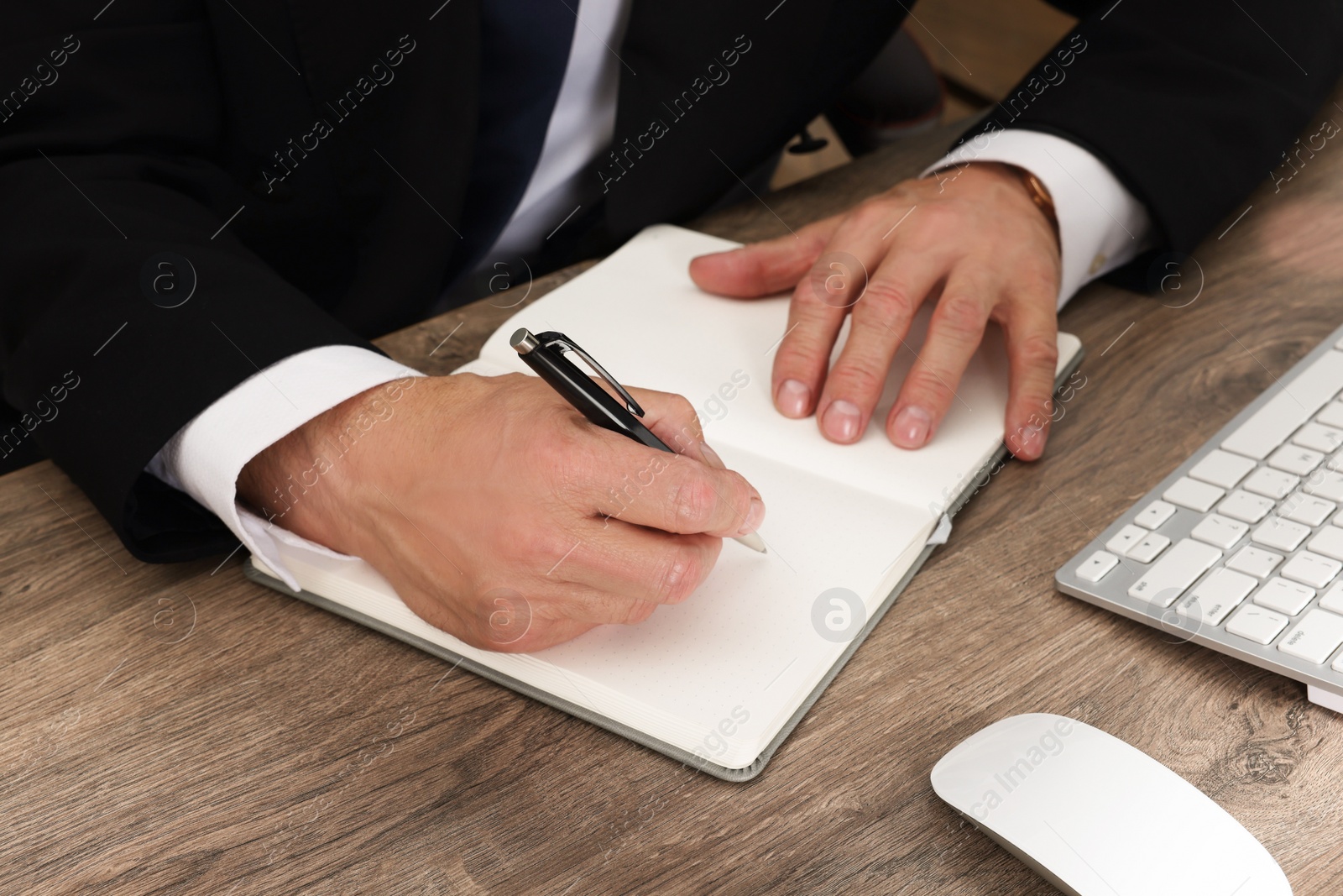 Photo of Boss working at wooden table indoors, closeup