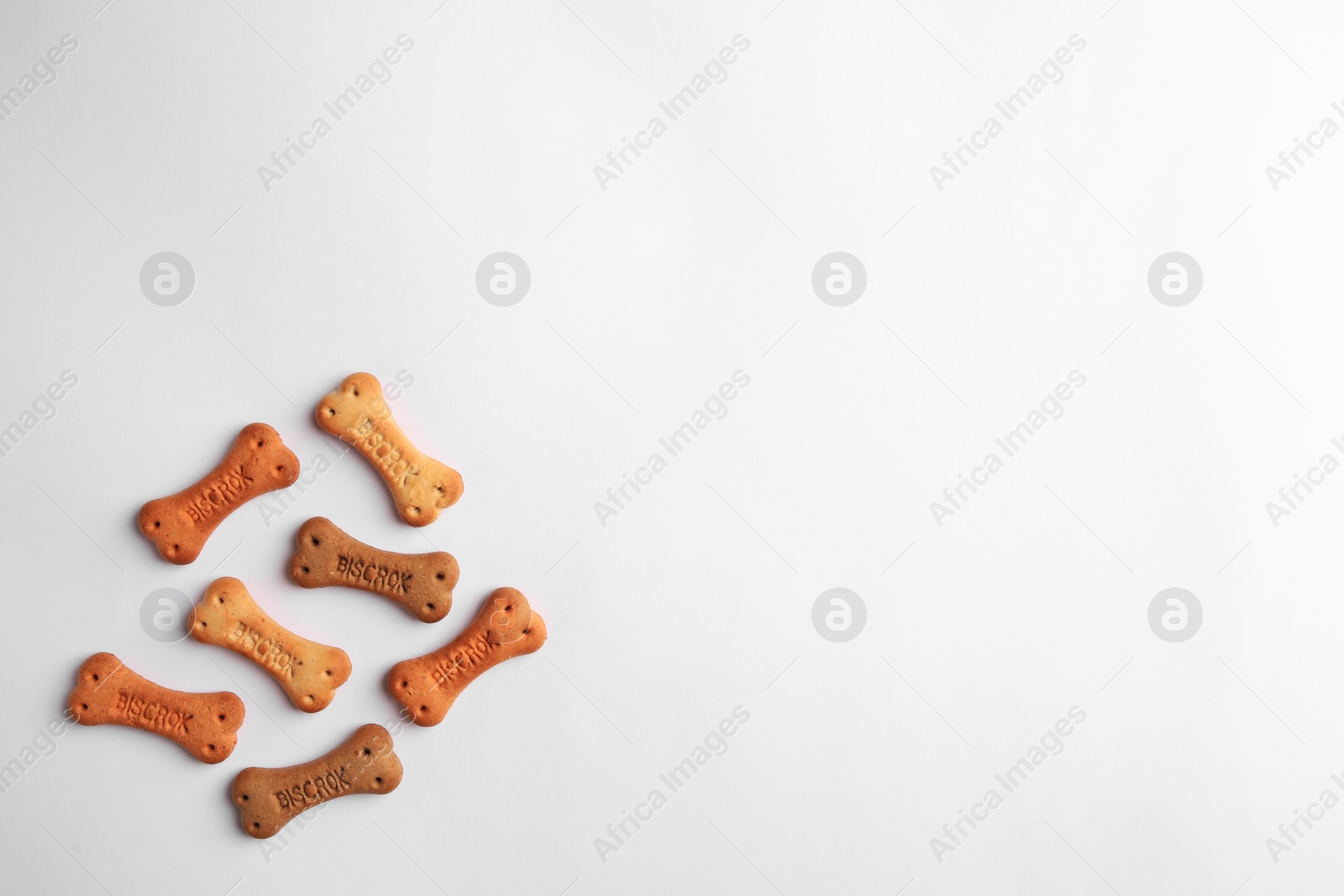 Photo of Bone shaped dog cookies on white background, top view. Space for text