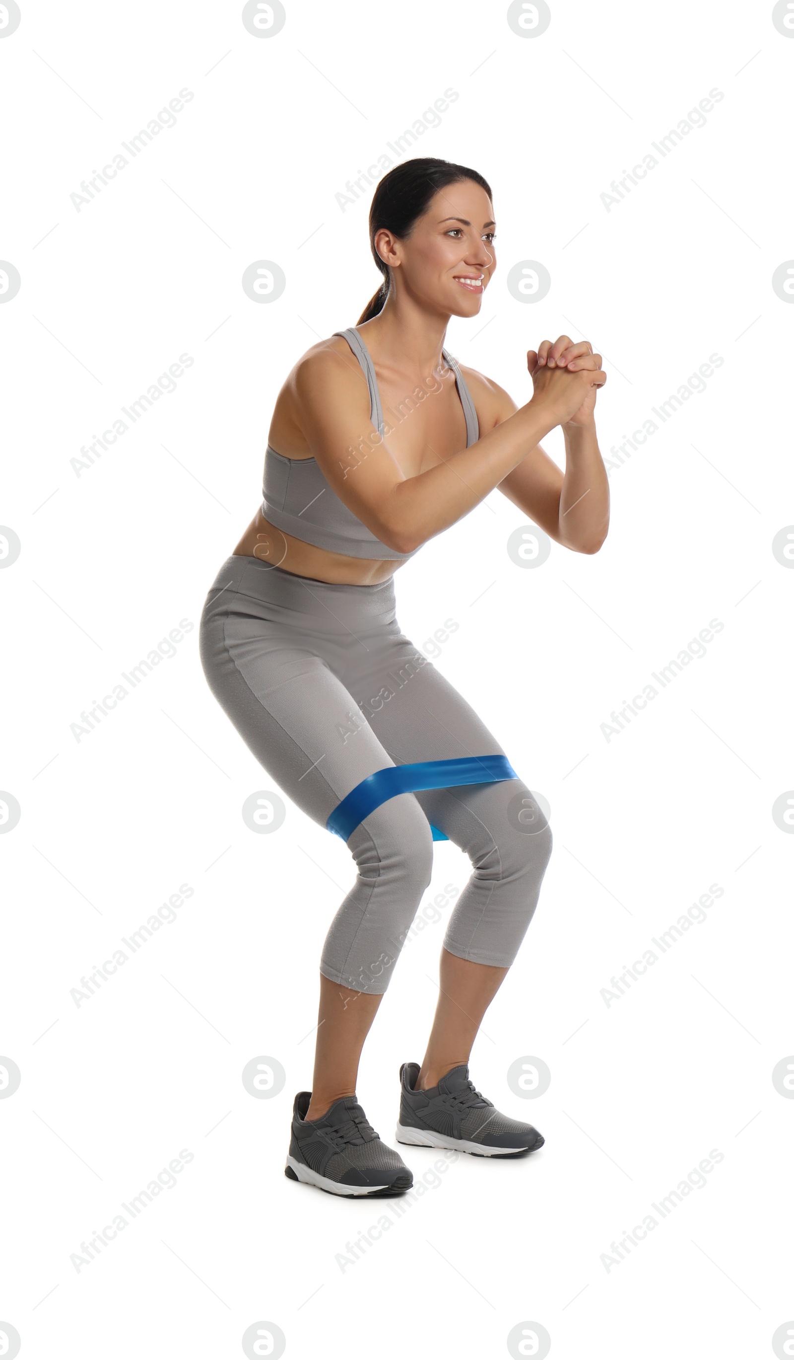 Photo of Woman doing squats with fitness elastic band on white background