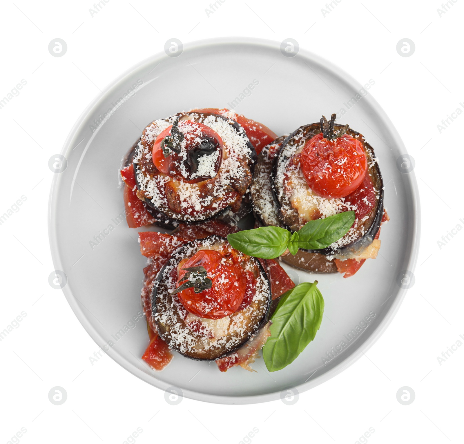 Photo of Baked eggplant with tomatoes, cheese and basil in plate isolated on white, top view