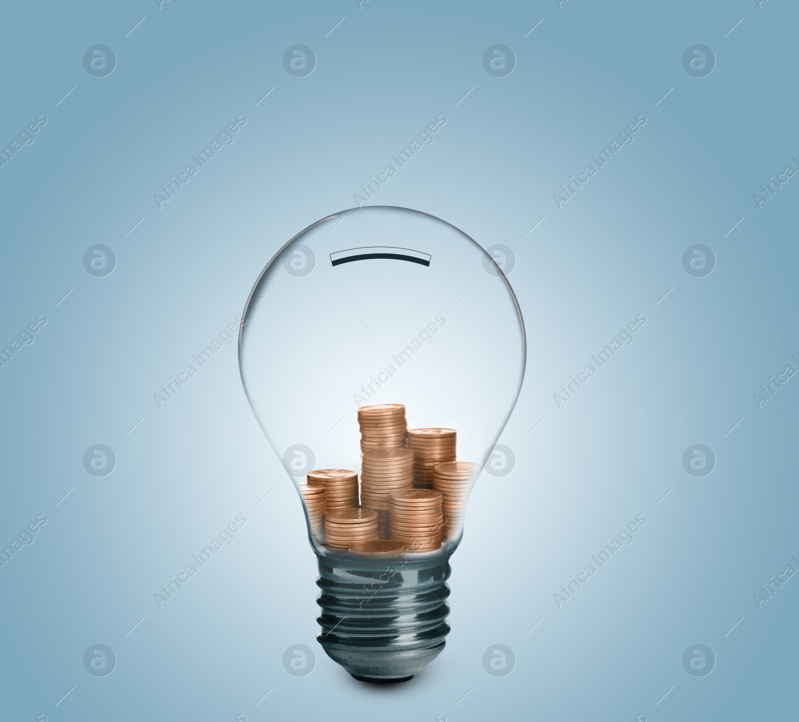 Image of Light bulb with stacked coins inside on light blue background. Energy efficiency, loan, property or business idea concepts