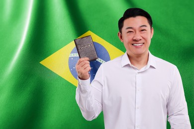 Immigration. Happy man with passport against national flag of Brazil, space for text