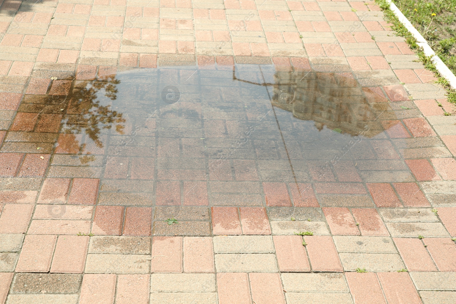 Photo of Puddle after rain on street tiles outdoors