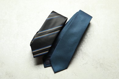 Photo of Two neckties on light textured table, top view