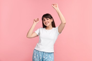 Photo of Happy woman in pyjama on pink background