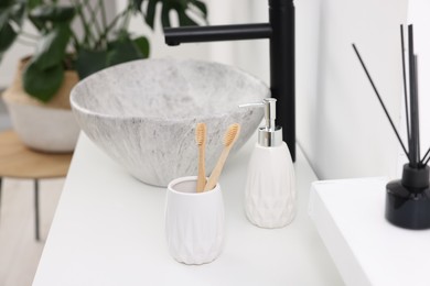 Different bath accessories and personal care products on bathroom vanity indoors