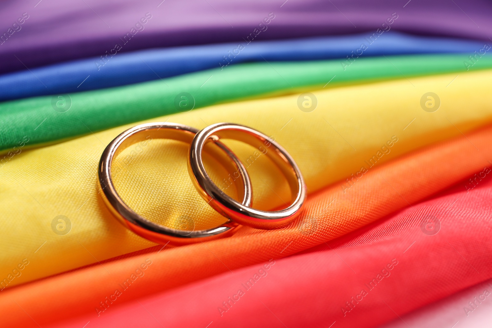 Photo of Wedding rings on rainbow LGBT flag, closeup