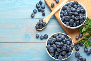 Photo of Tasty fresh blueberries on light blue wooden table, flat lay. Space for text