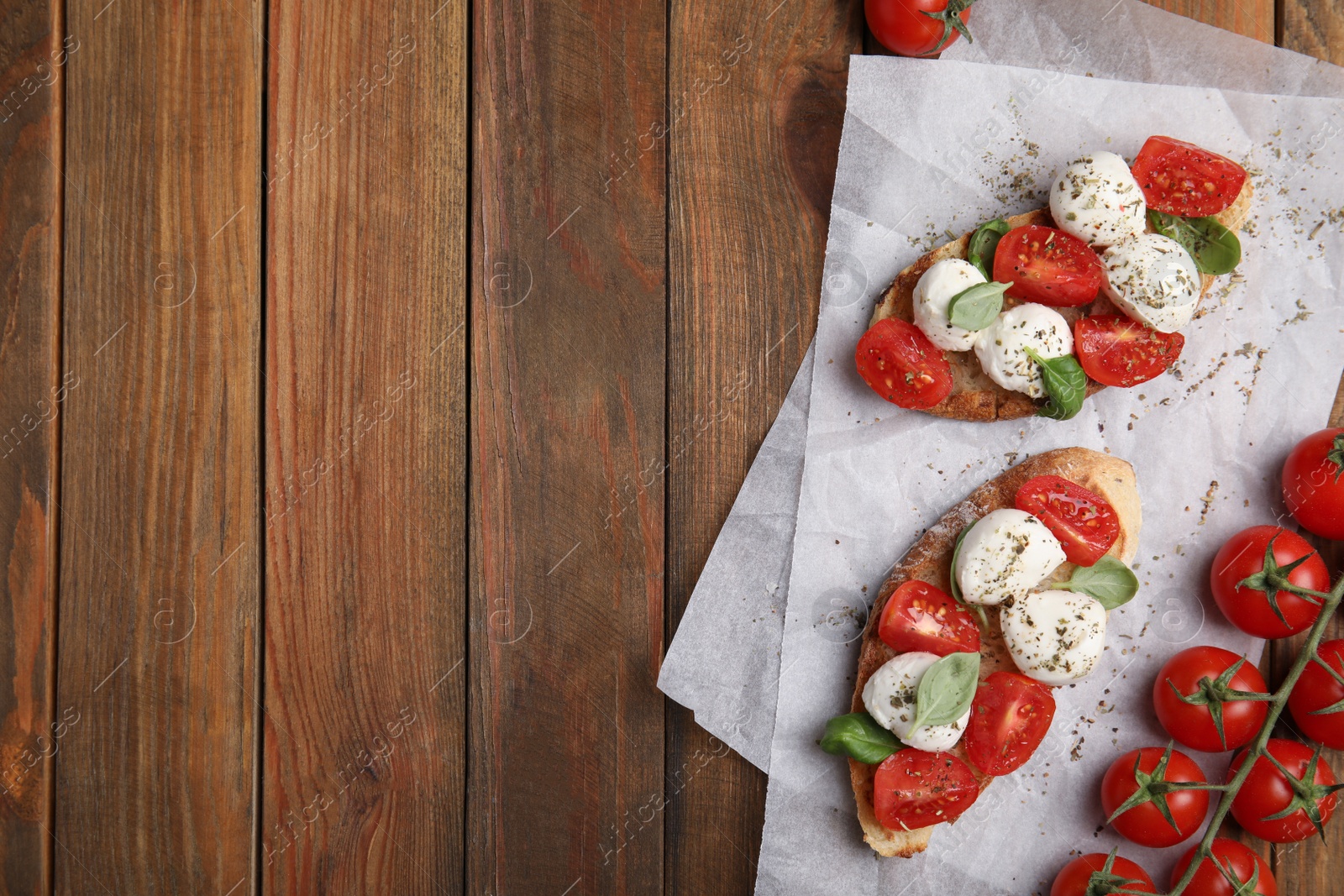 Photo of Delicious sandwiches with mozzarella, fresh tomatoes and basil on wooden table, flat lay. Space for text