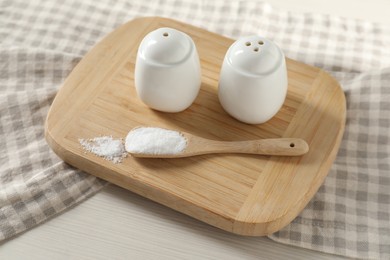 Photo of Spice shakers with salt on white wooden table