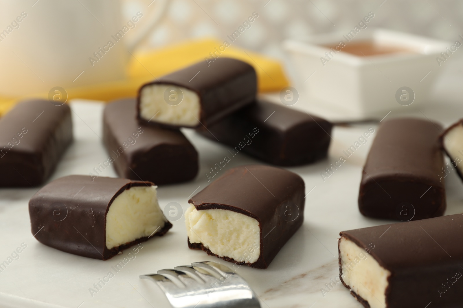 Photo of Glazed curd cheese bars on white board, closeup