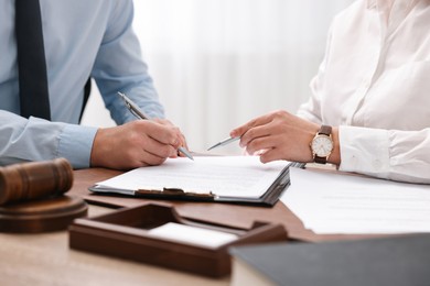 Photo of Lawyers working with documents at table in office, closeup