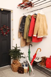 Christmas wreath hanging on wooden door, festive decoration and outwear indoors