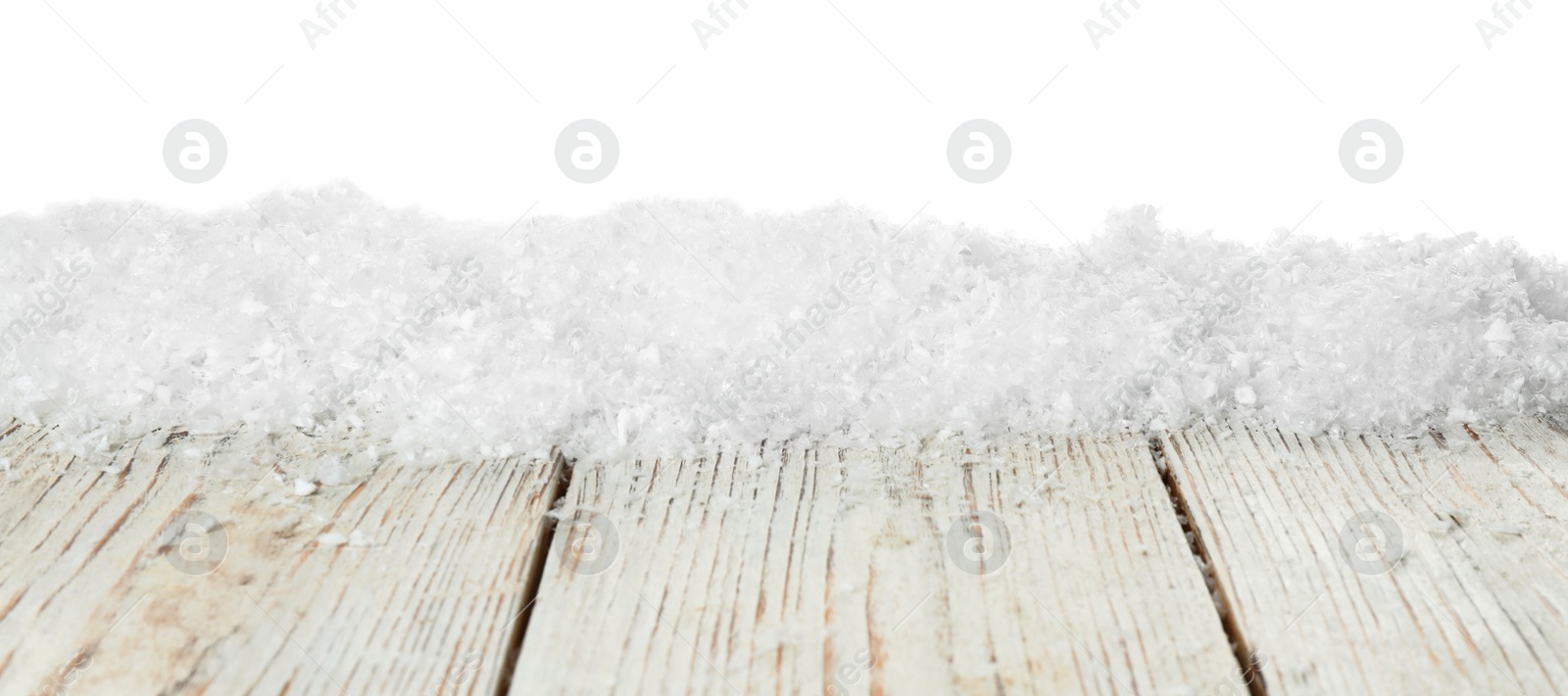 Photo of Heap of snow on wooden table against white background. Christmas season