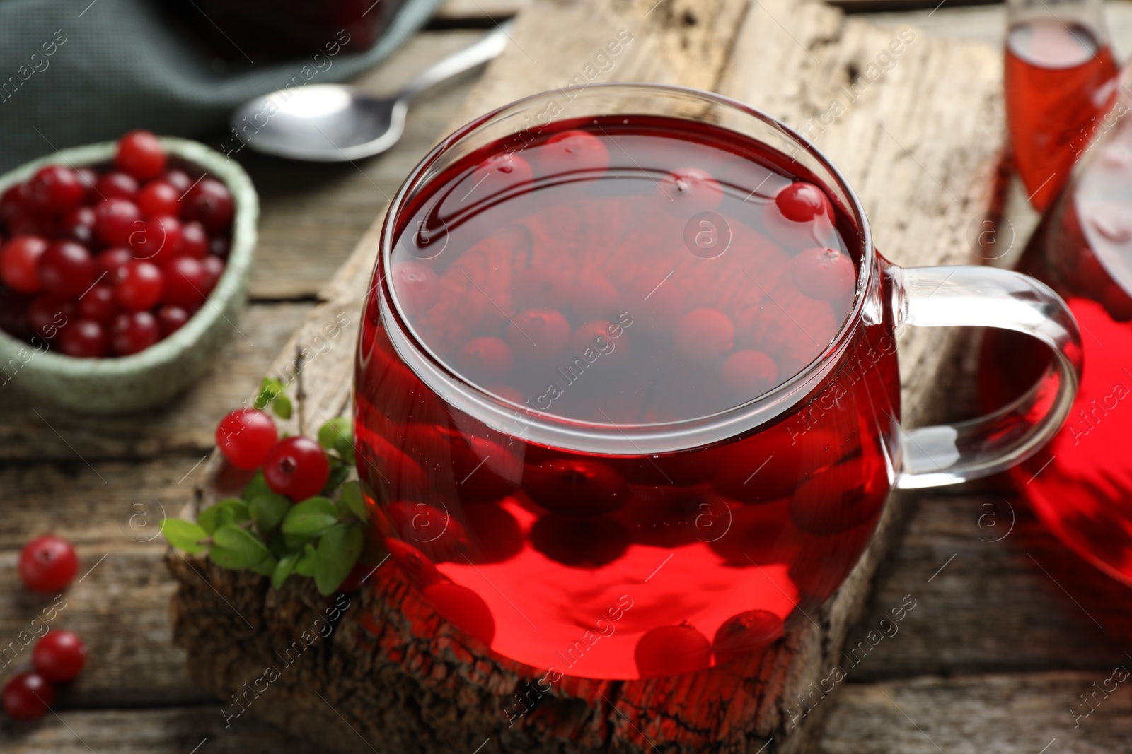 Photo of Delicious cranberry tea and berries on wooden table, closeup