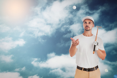 Image of Young man with golf club and ball against blue sky. Space for design