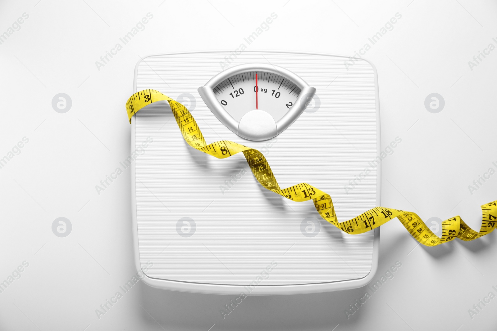 Photo of Scales and measuring tape on white background, top view