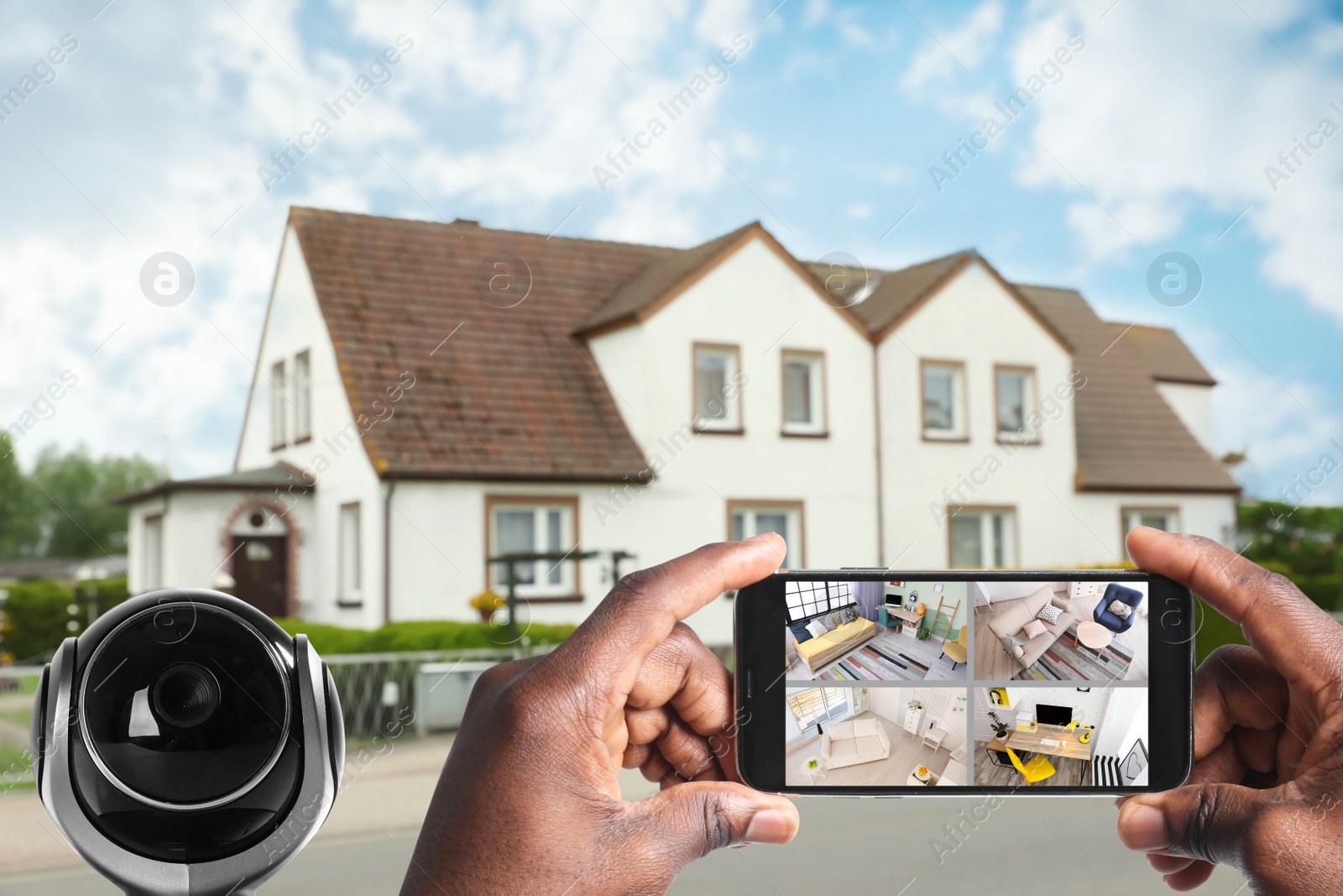 Image of Home security system. African American man monitoring modern CCTV cameras on smartphone near his house, closeup