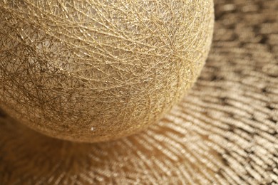 Photo of Texture of sphere made with golden threads, closeup