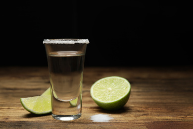 Photo of Mexican Tequila shot with salt and lime on wooden table. Space for text