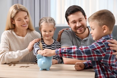 Planning budget together. Family with piggy bank and coins at table indoors
