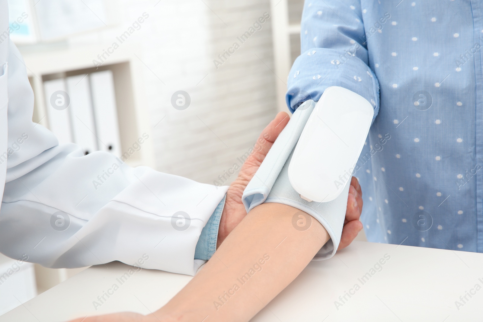 Photo of Doctor checking young woman's pulse with medical device in hospital, closeup