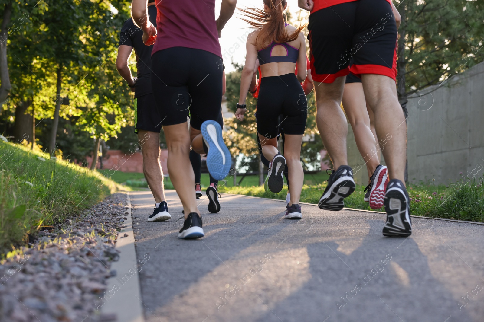 Photo of Group of people running outdoors, back view