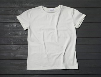 Stylish white T-shirt on gray wooden table, top view