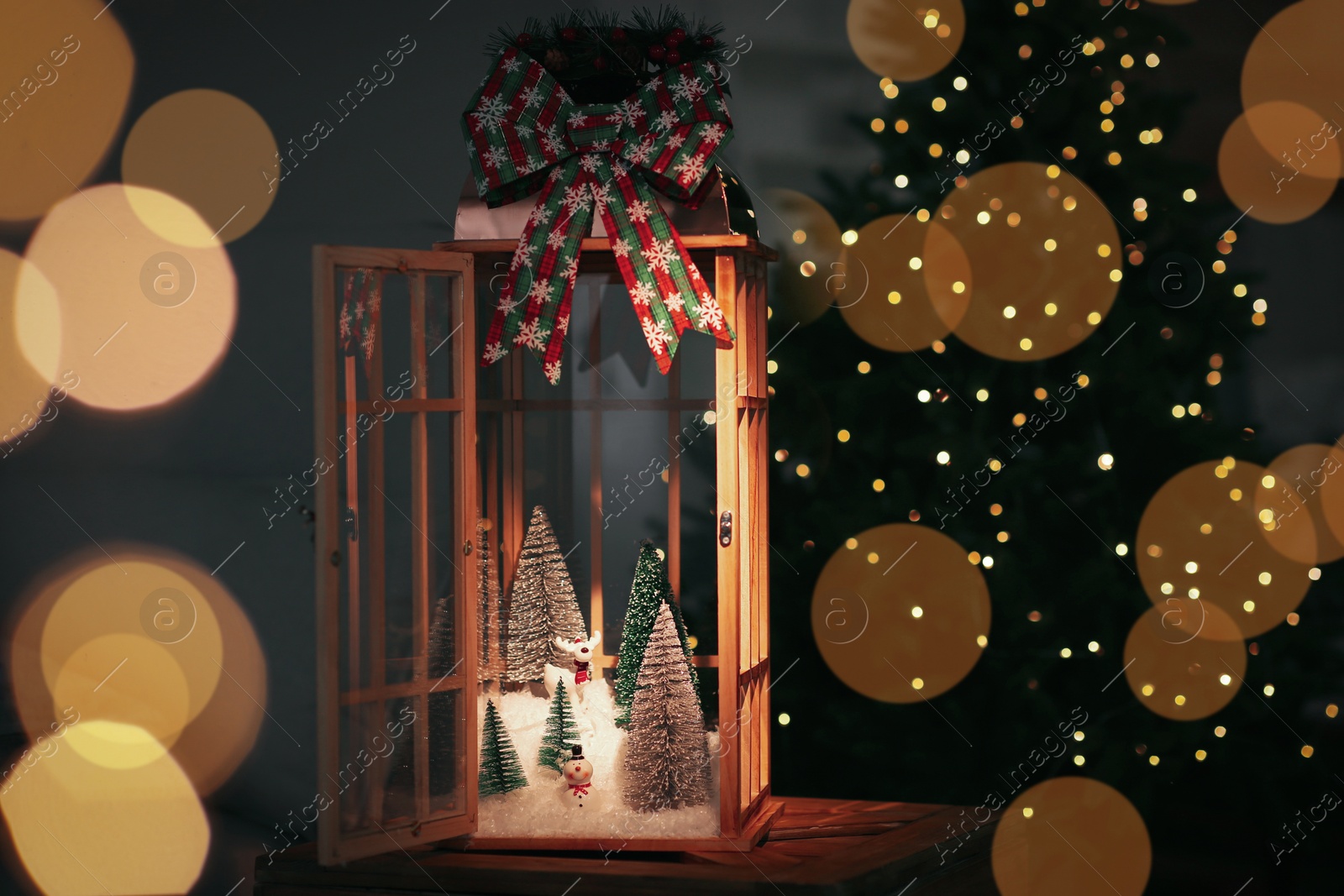 Photo of Vintage wooden lantern with beautiful Christmas composition surrounded by blurred festive lights indoors