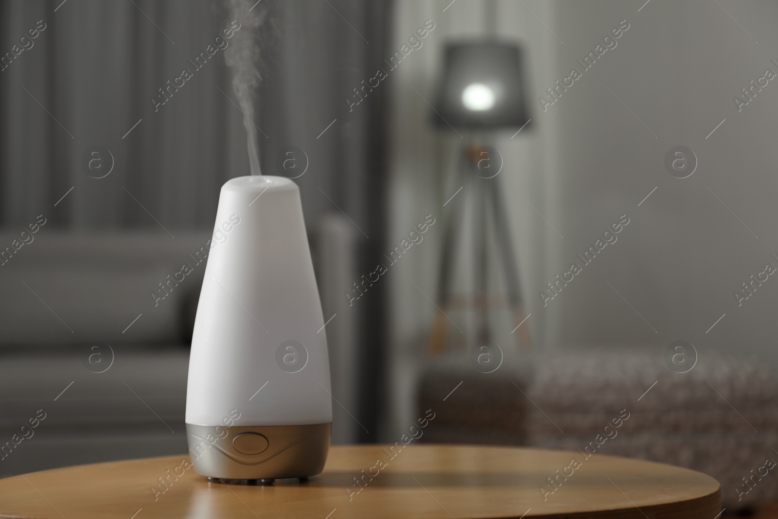 Photo of Aroma oil diffuser on wooden table indoors, space for text. Air freshener