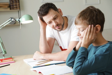 Photo of Dad struggling to help his son with school assignment at home