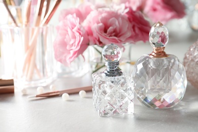 Different perfume bottles on dressing table, space for text
