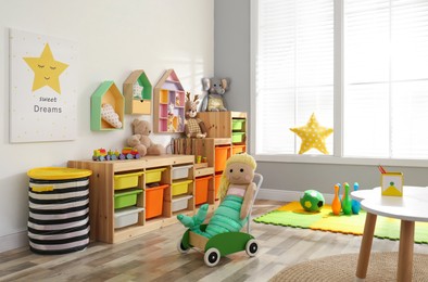 Stylish playroom interior with shelving unit and different soft toys