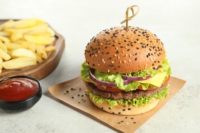 Photo of Burger with delicious patty, french fries and sauce on light table, closeup
