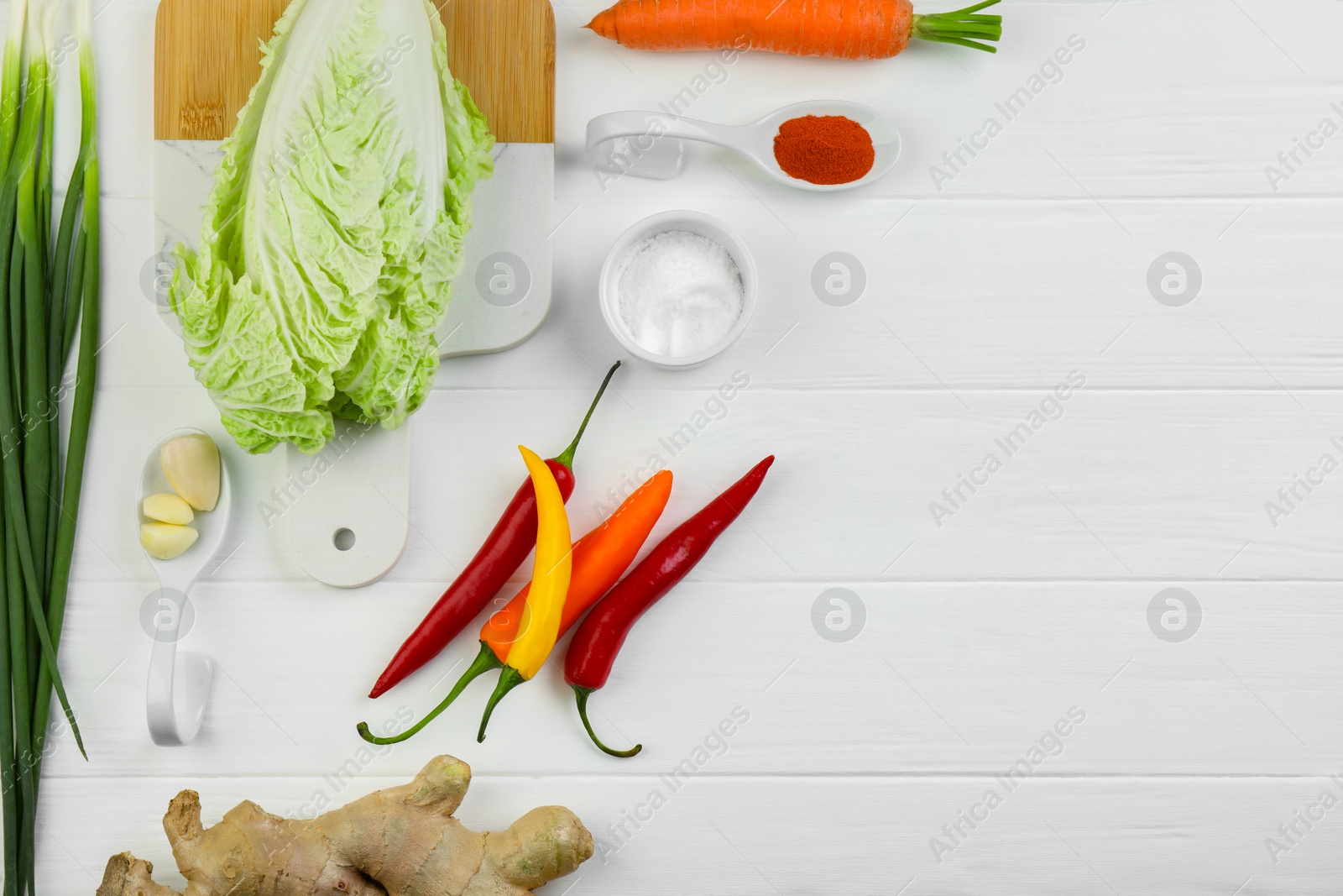 Photo of Flat lay composition with fresh Chinese cabbages and ingredients on white wooden table. Space for text