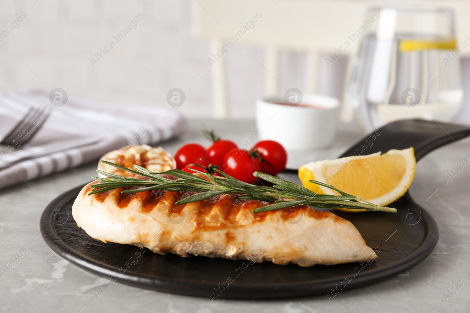 Photo of Delicious grilled chicken with vegetables on marble table