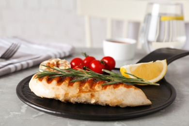 Photo of Delicious grilled chicken with vegetables on marble table