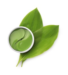Photo of Jar of under eye patches and green leaves isolated on white, top view. Cosmetic product