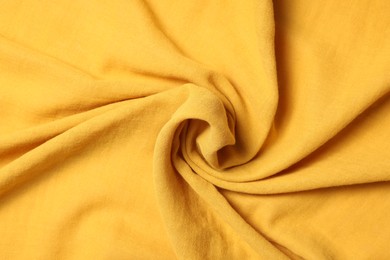 Texture of soft yellow crumpled fabric as background, top view