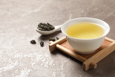 Photo of Cup of Tie Guan Yin oolong tea on table. Space for text