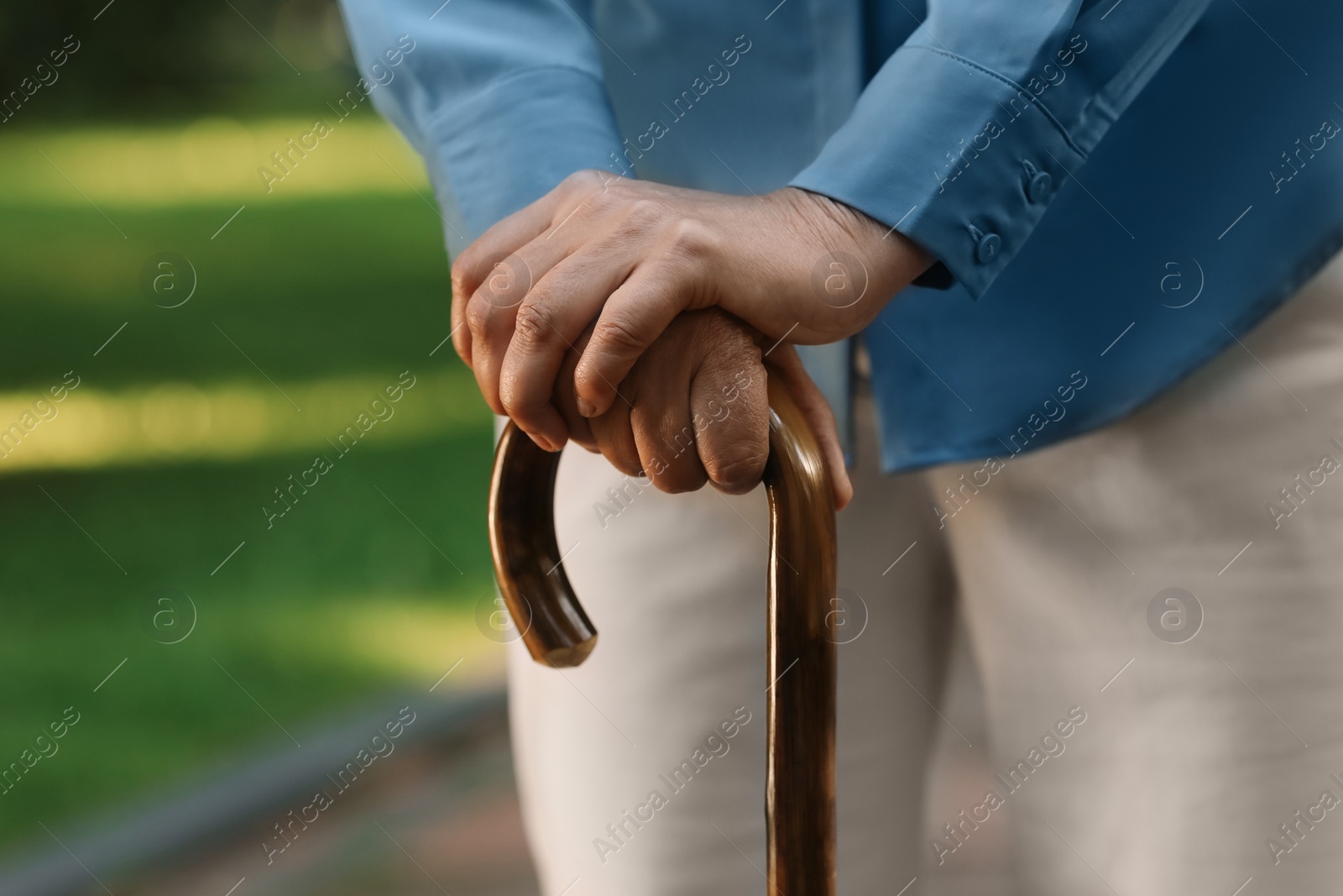 Photo of Senior woman with walking cane outdoors, closeup